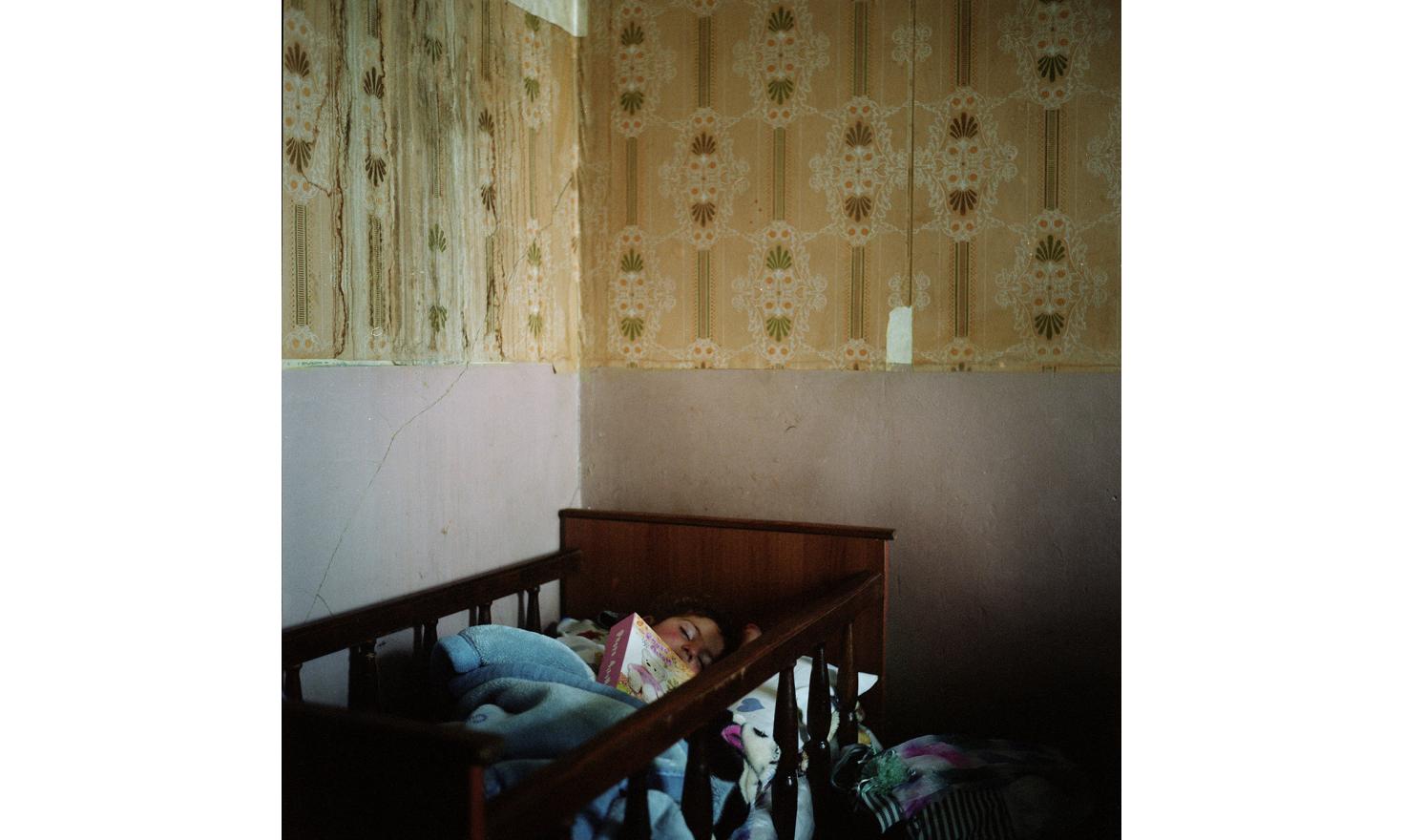Lilith, Anoush's daugther, fell asleep with the photo album of her father. He went to Russia to work for years to earn money to build them a house in the village.