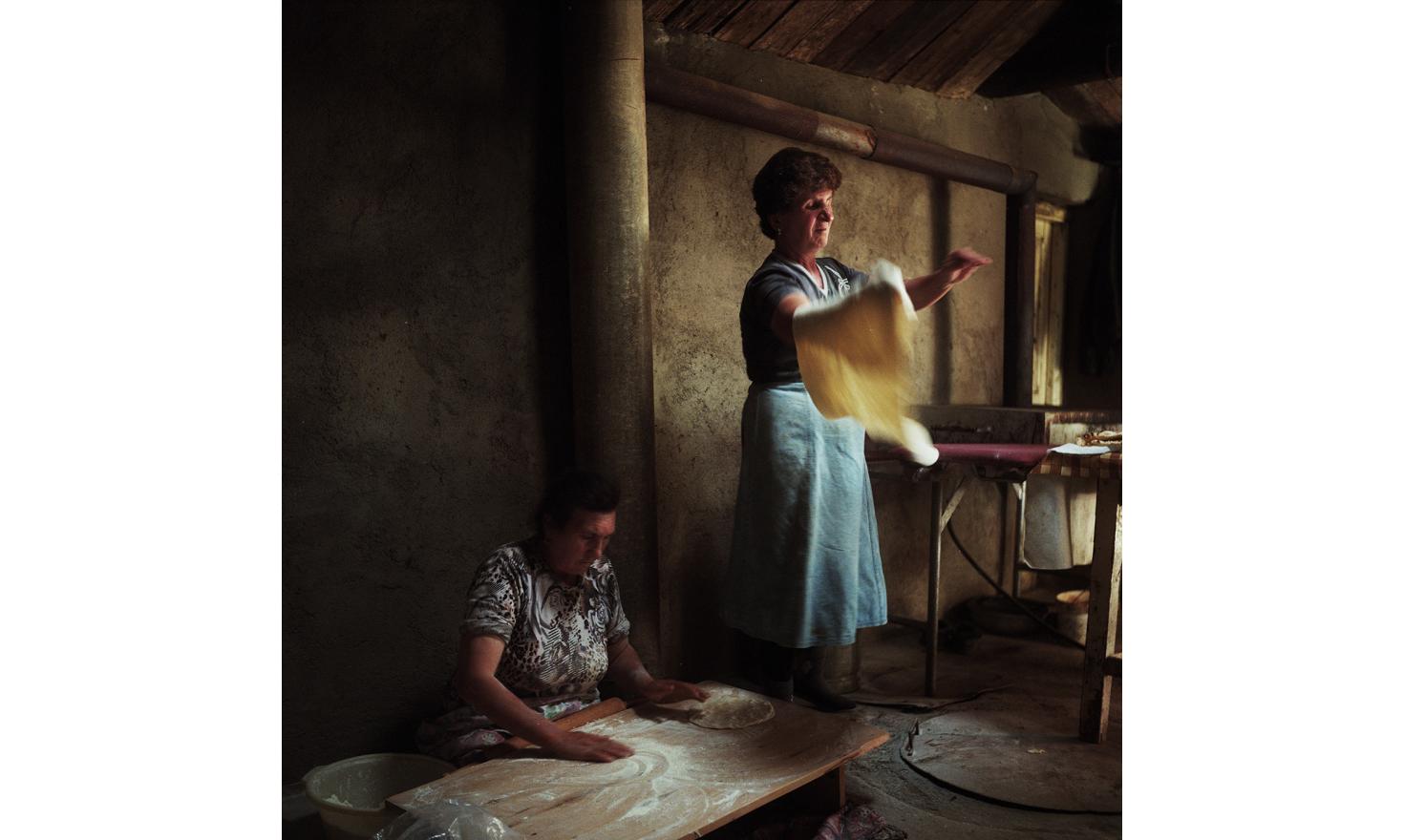 Asya (right) cooks lavash with her neighbor Venera (left). The 3 daughters of Asya are married to men working in Russia. Her young son Artashes studies economics and works every summer in Russia. Once he finishes his studies, he intends to work in Russia.