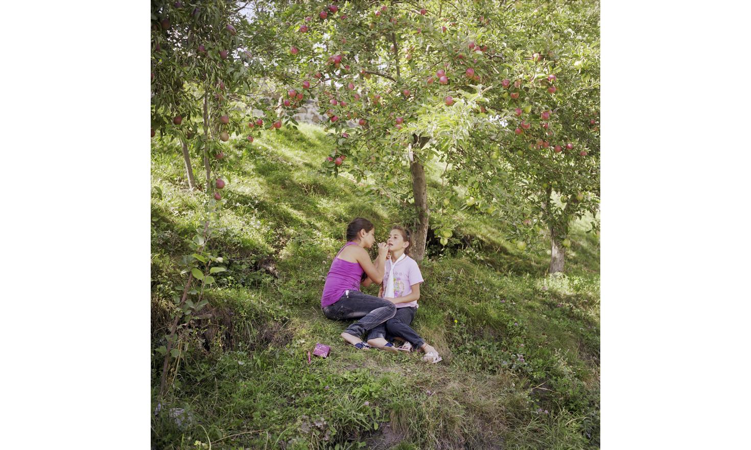 Ana's daughters are playing in the garden. Their father works in Russia.