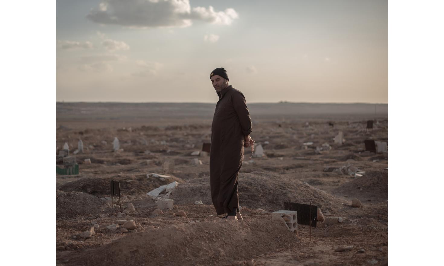 The lost children of the caliphate Mohammed Khalil, head of the village’s council, looks at the grave of a child from Al-Hawl’s camp.